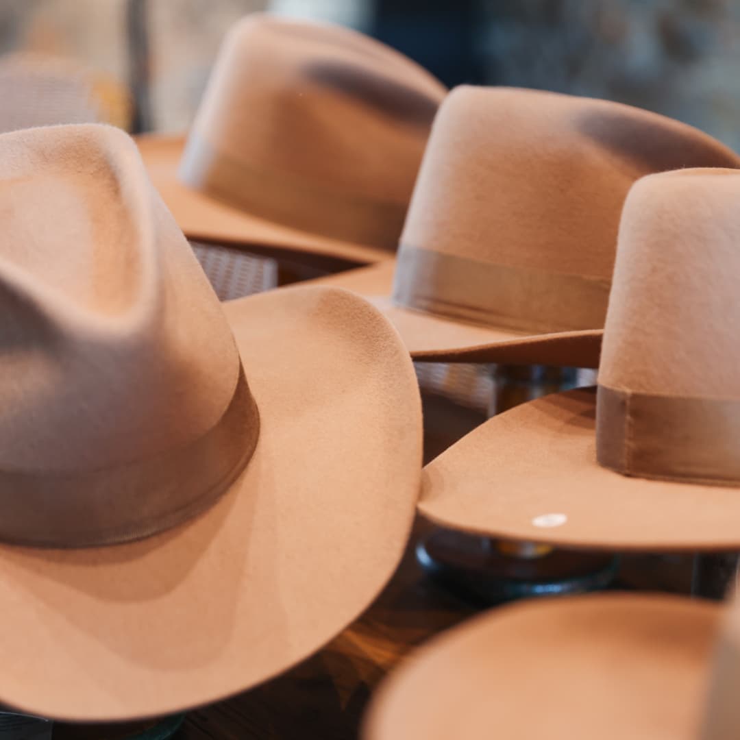 Western felt hat TCMF Wheeler by PHYLLi Designs with taupe Japanese grosgrain ribbon band displayed on a wooden table.