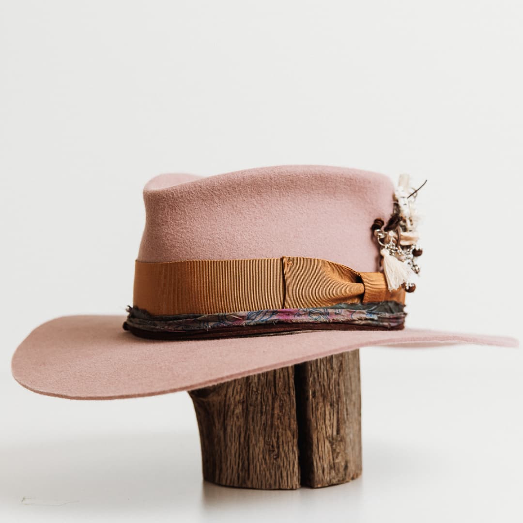 Front left angle of The Blush felt hat by PHYLLi Designs featuring vintage copper grosgrain bow band and suede string.