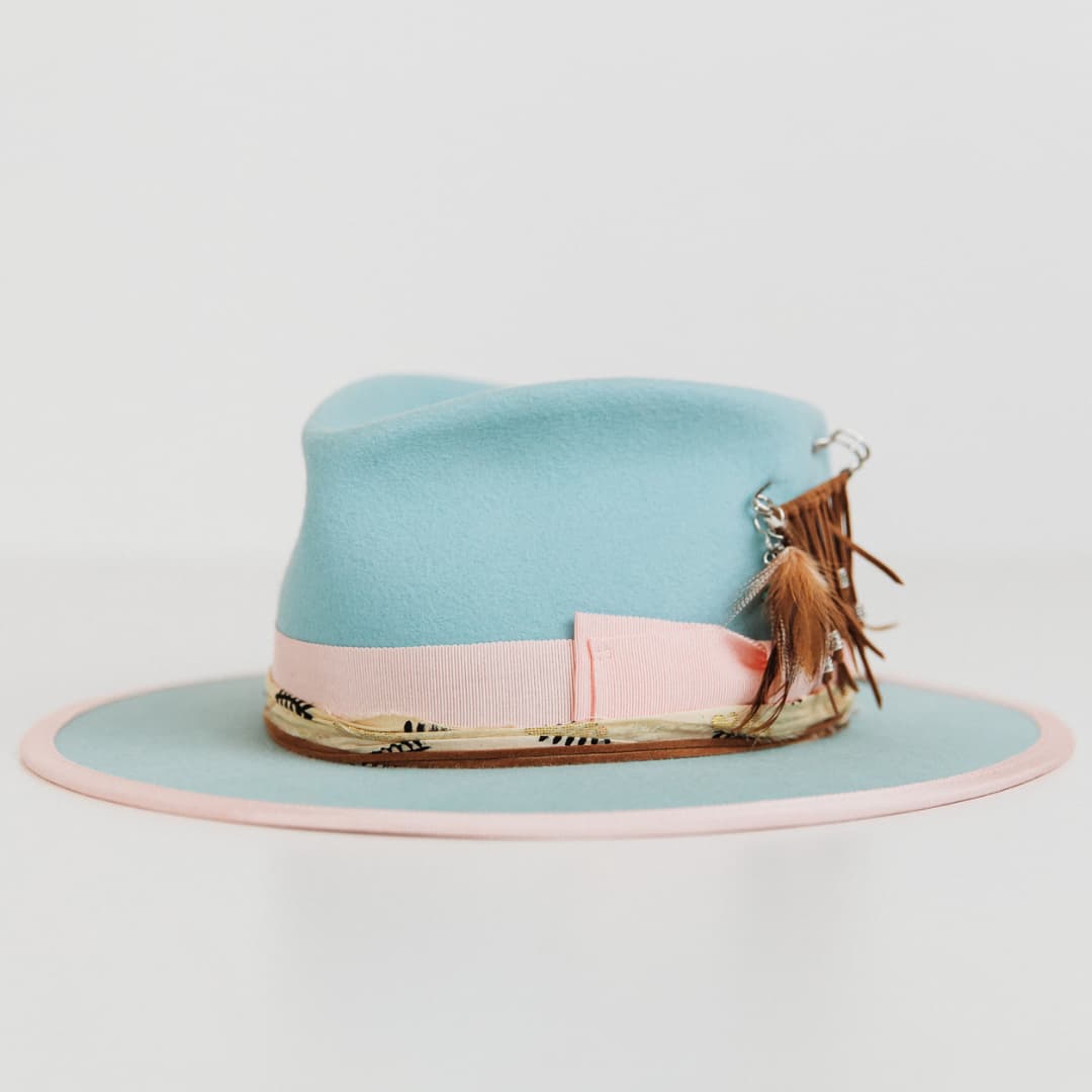 Front left angle of The Cyan felt hat by PHYLLi Designs with sherbet pink grosgrain bow band and pink brim trim.