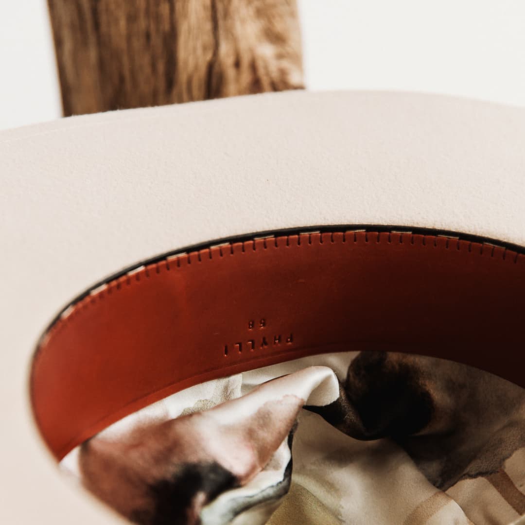Interior detail of The Dartbrook felt hat showing leather sweatband stamped PHYLLi and silk lining.