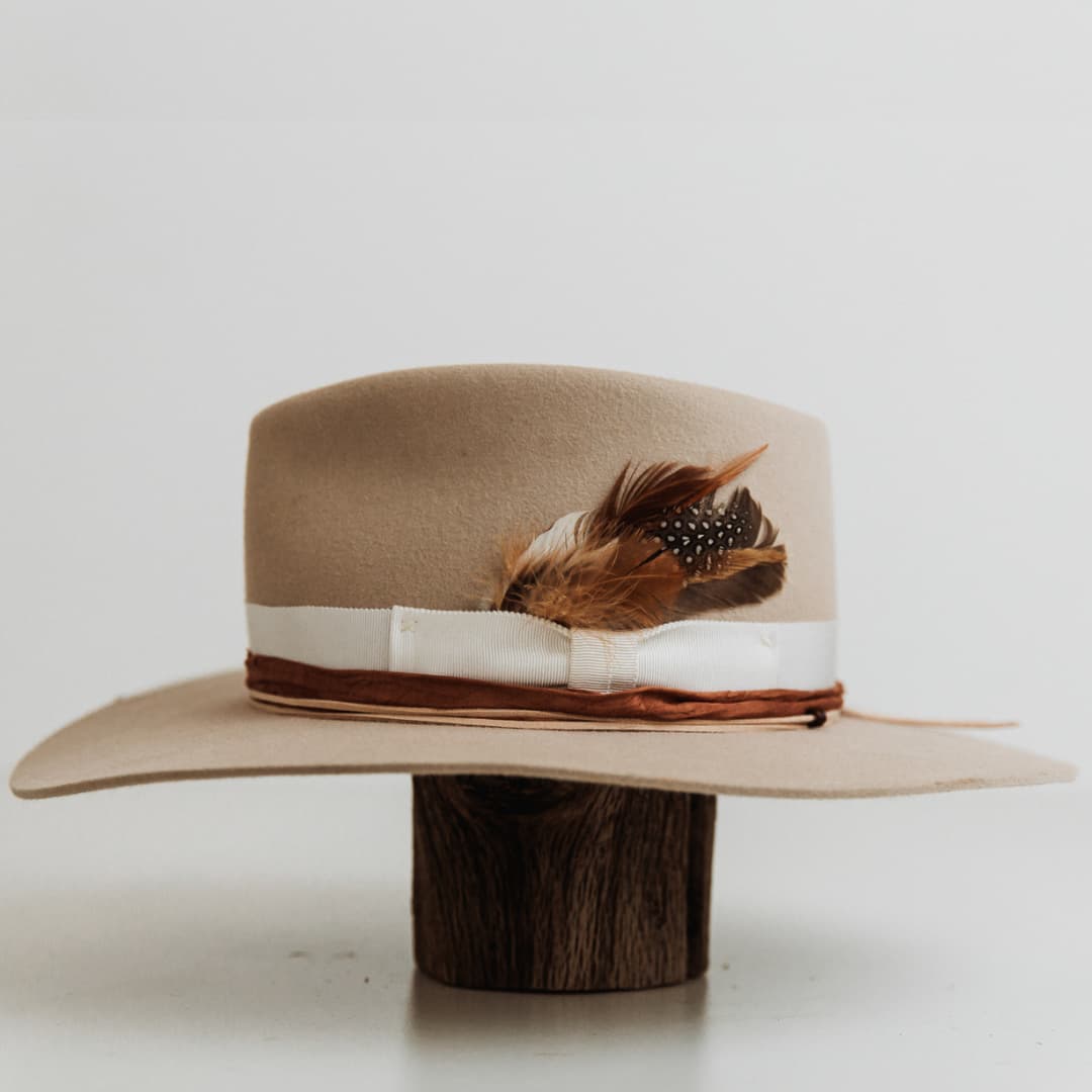 Left side view of The Dartbrook felt hat by PHYLLi Designs with sari silk trim and suede string with wooden beading.