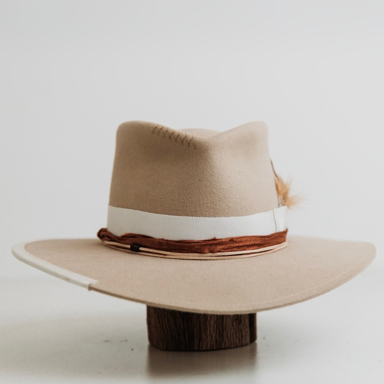 Front view of The Dartbrook beige felt hat by PHYLLi Designs with ivory grosgrain band and rust sari silk trim.