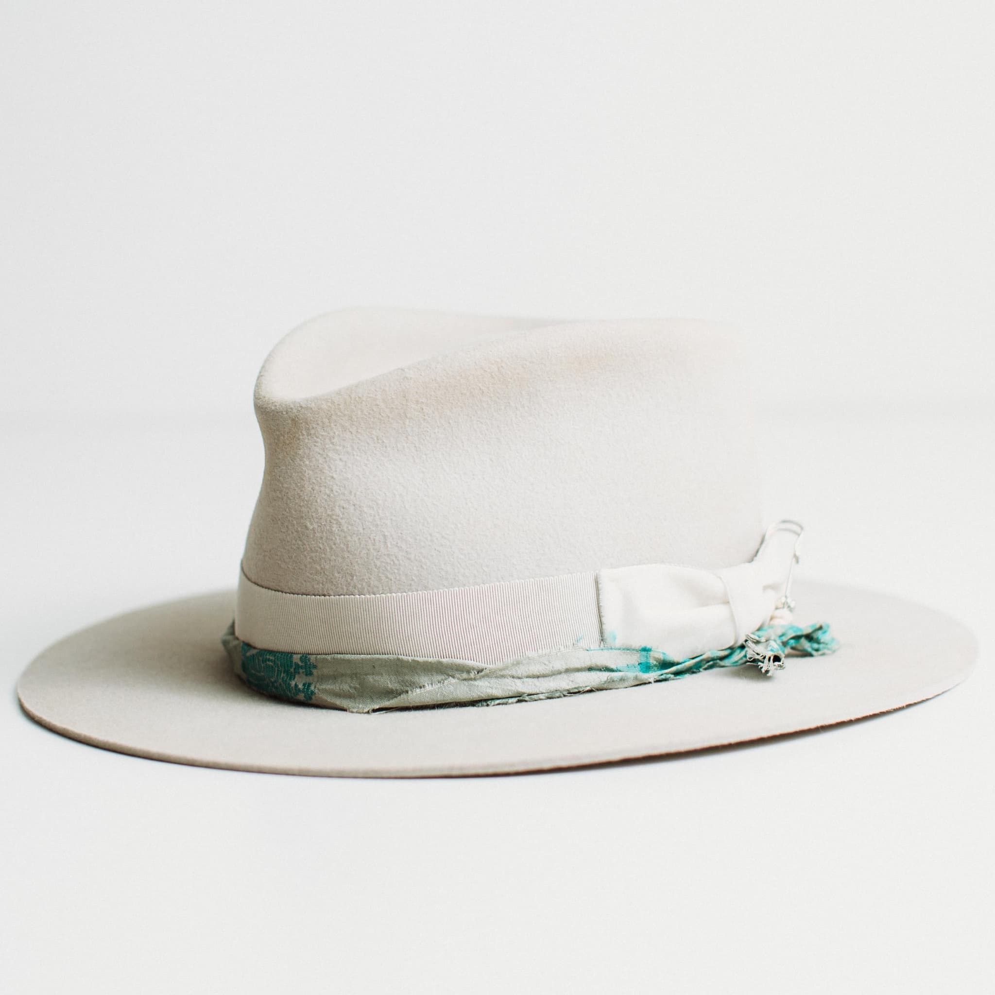 Front left angled view of The Dove dove felt hat with grosgrain band and sari silk trim.