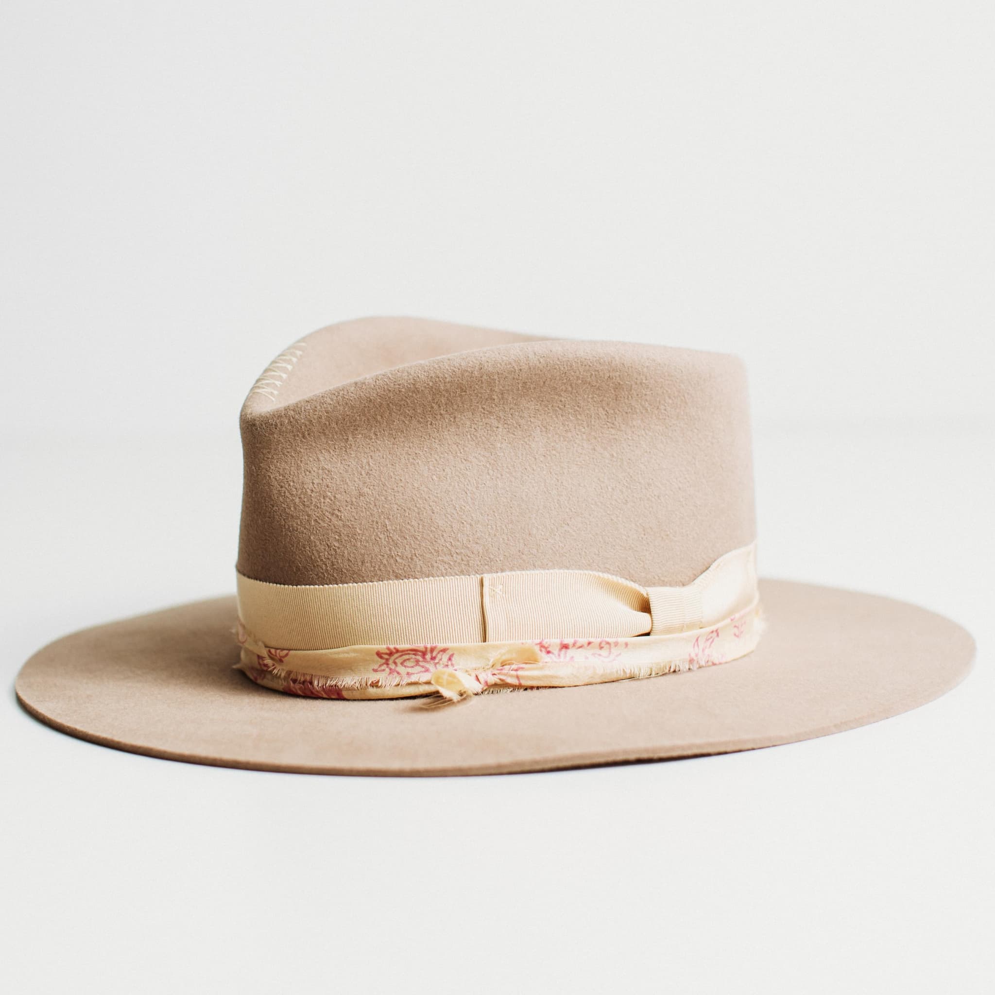 Front left angled view of The Fawn sahara felt hat with grosgrain bow band and patterned sari silk trim.