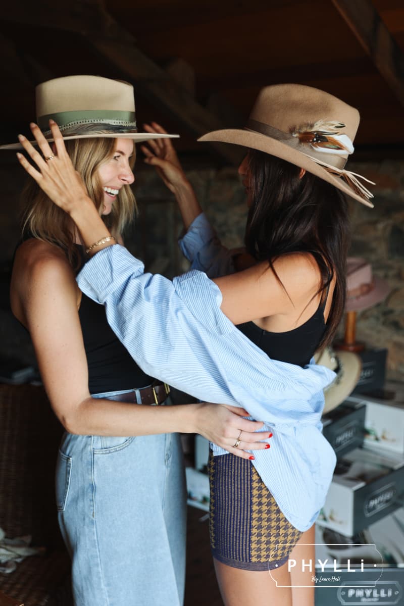 Guests trying on finished custom hats during the PHYLLi Group Hat Party experience.