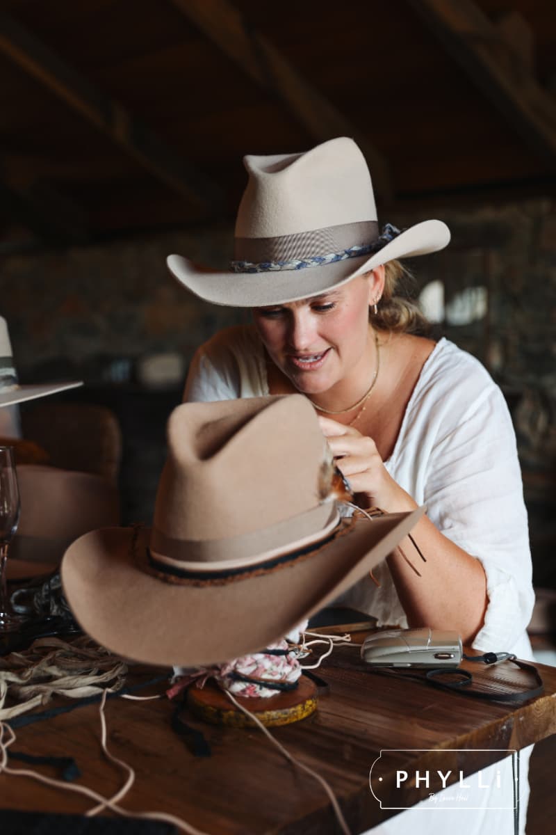 PHYLLi founder Laura Hall hand-finishing trims onto a felt hat during the Group Hat Party experience.