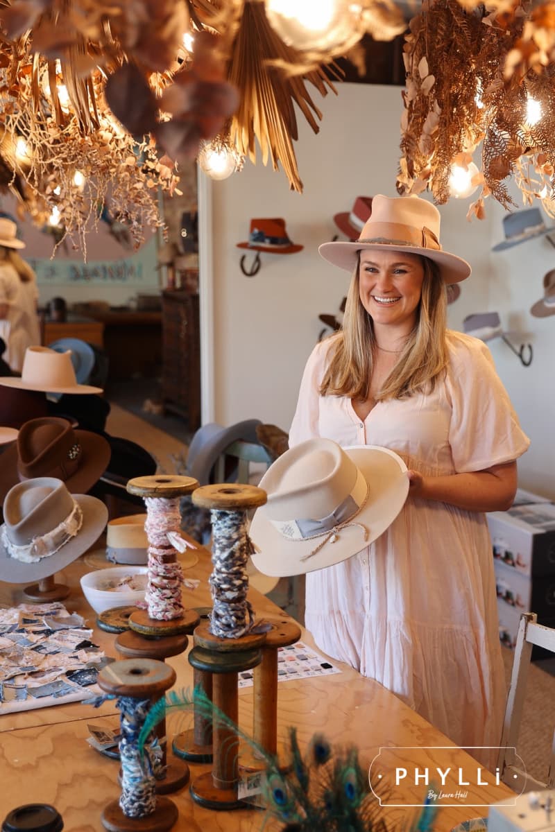 PHYLLi hat styling table with felt hats, trims and ribbons prepared for a private hat party experience.