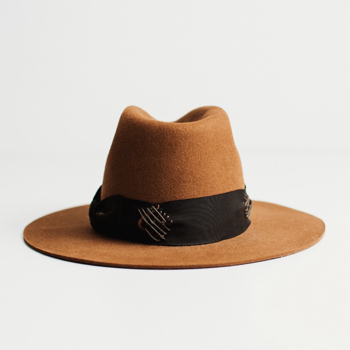 Back view of The Open Road caramel felt hat with black grosgrain band and grey darning patch details.