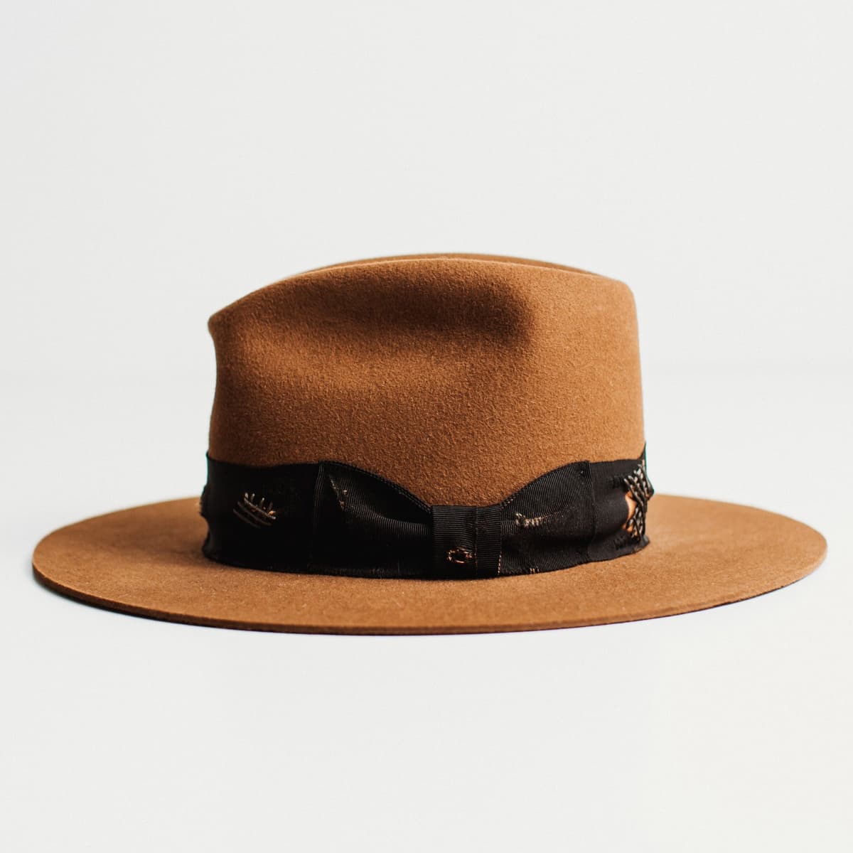 Left side view of caramel felt hat with Open Road cowboy crown and black grosgrain band with grey darning patches by PHYLLi Designs.