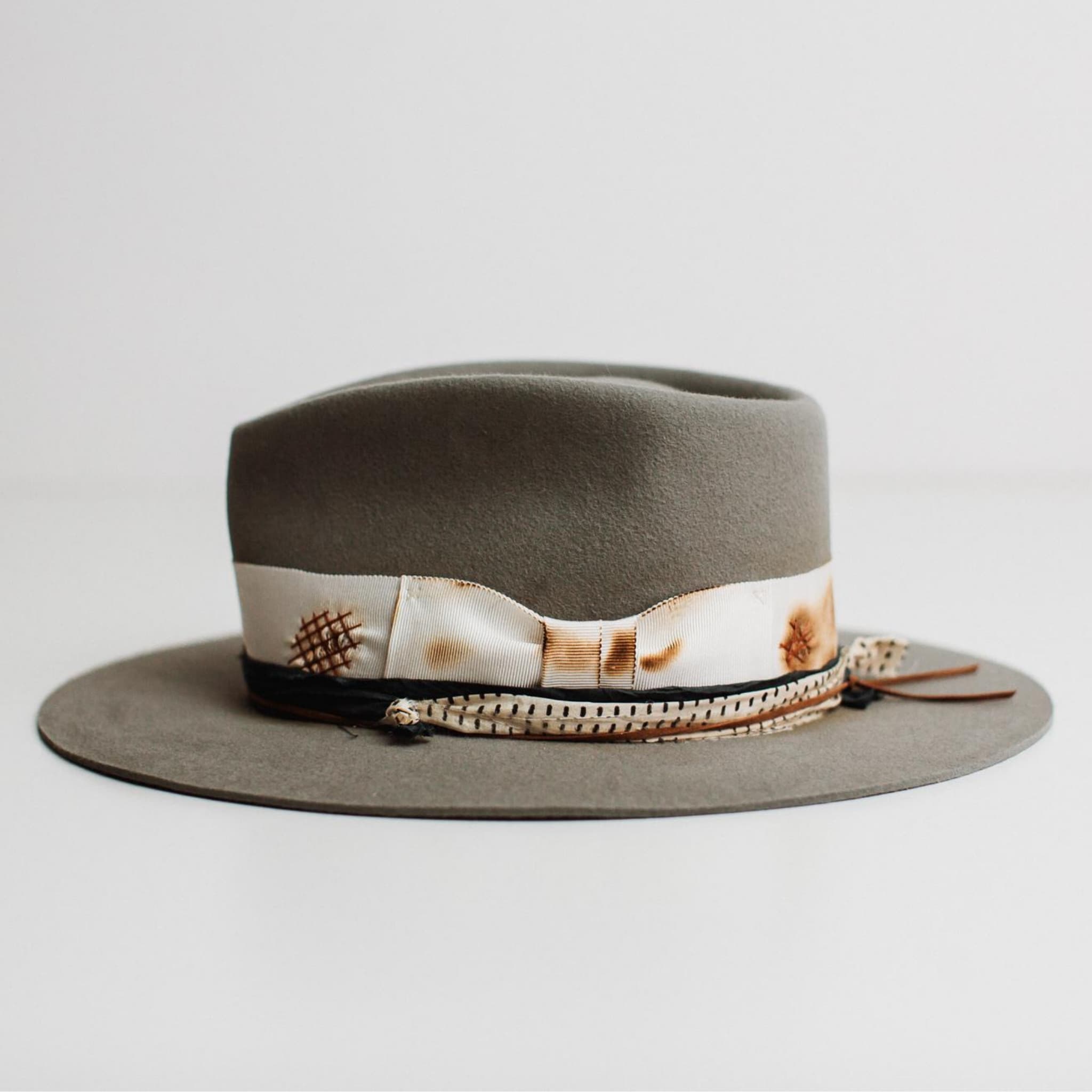 Left side view of The Paver taupe felt hat by PHYLLi Designs with sari silk trim and tan suede string.