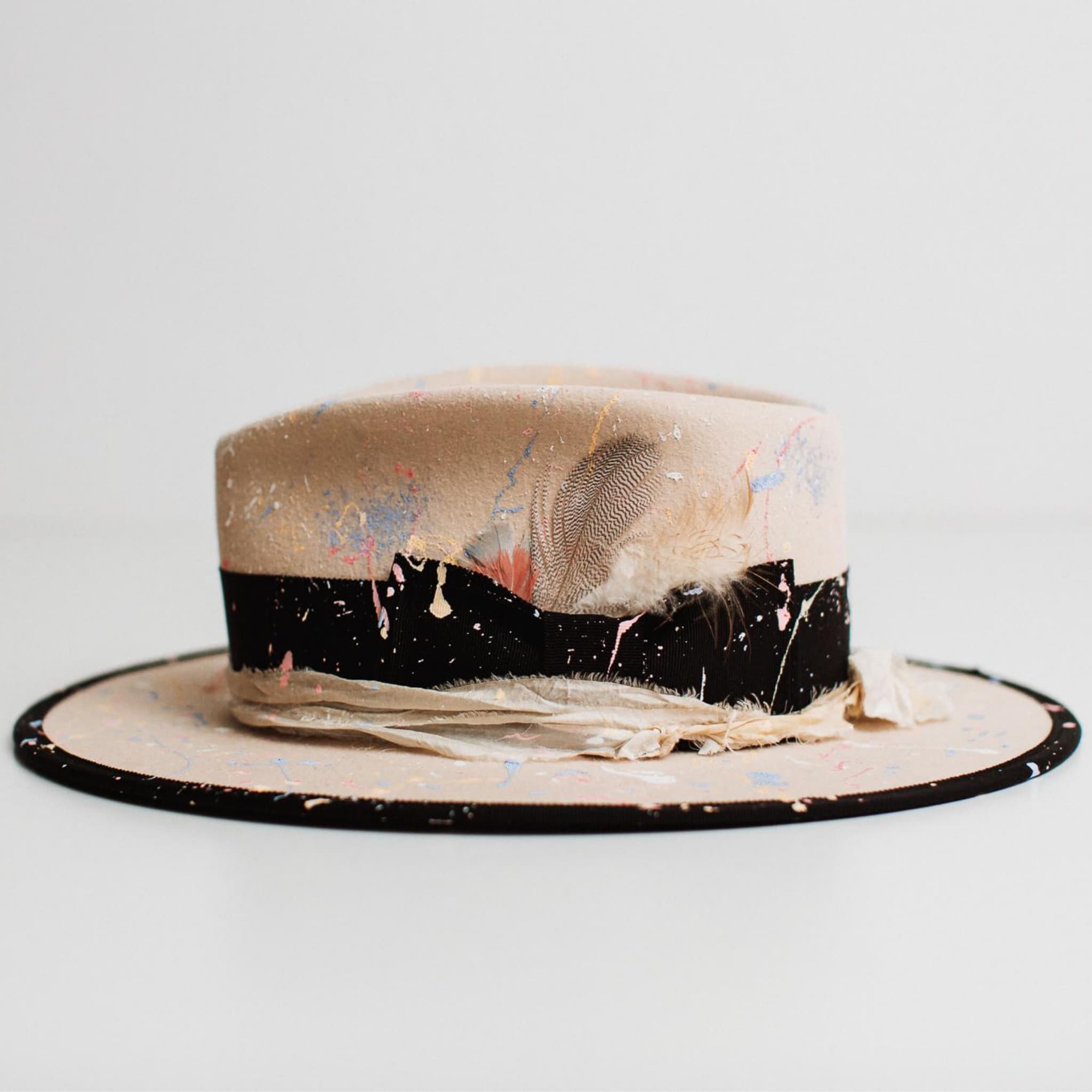 Left side view of Pollock beige felt hat by PHYLLi Designs with black grosgrain band and cream sari silk trim.