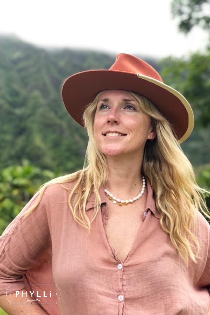 Woman wearing the Producer felt hat in spiced pumpkin styled with a pink shirt outdoors.