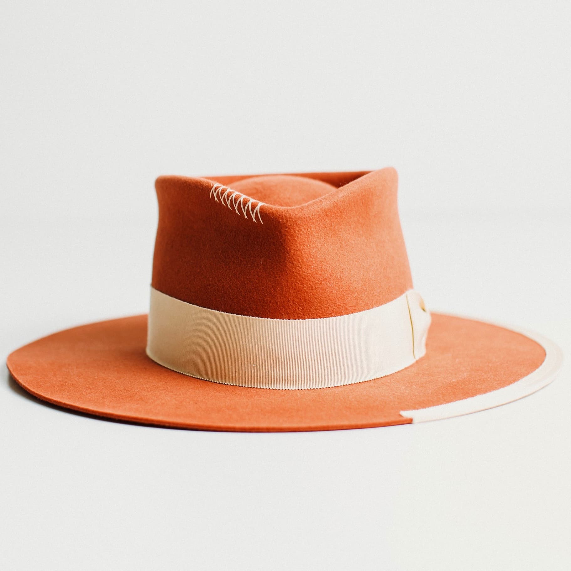 Producer wide-brim felt hat in spiced pumpkin with sand band by PHYLLi Designs on a light grey background.