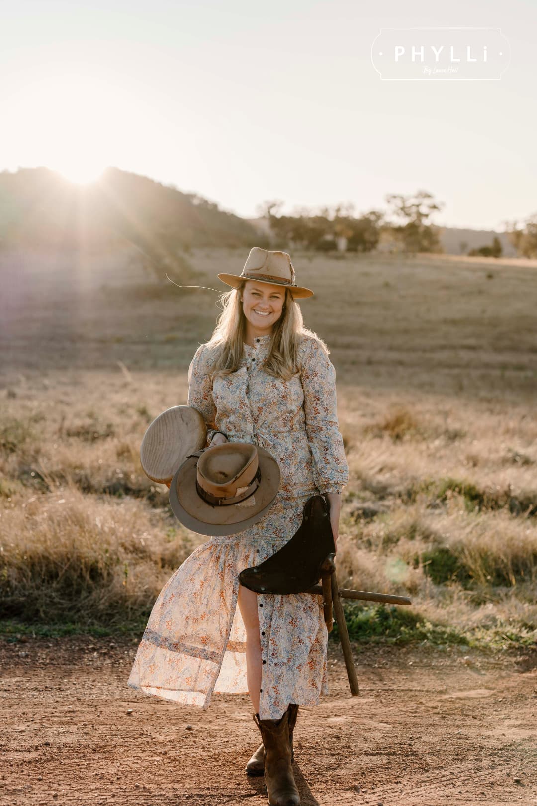Laura Hall wearing The Safari distressed Sahara felt hat while standing in rural Australian landscape at sunset.