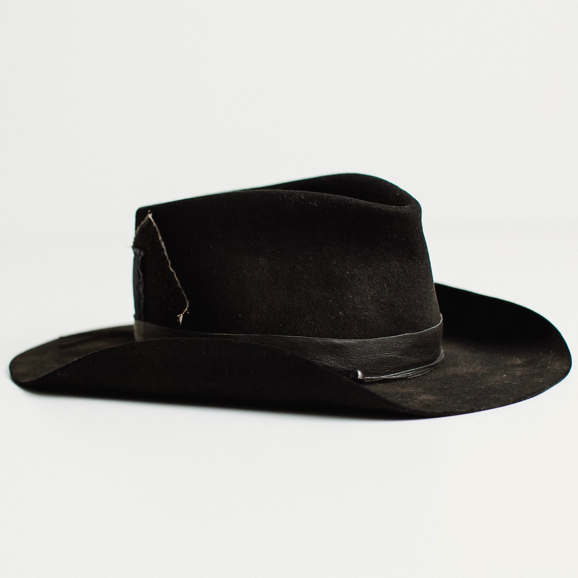 Front right angled view of black felt cowboy hat by PHYLLi Designs on a white background.