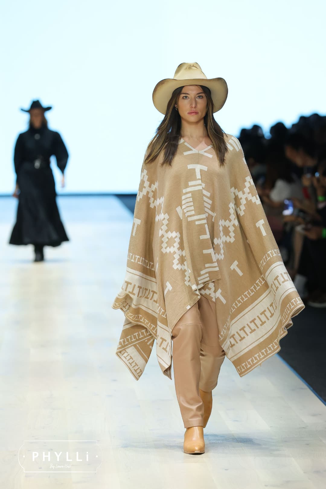 Model walking runway wearing The Wheeler premium felt hat in distressed Beige.