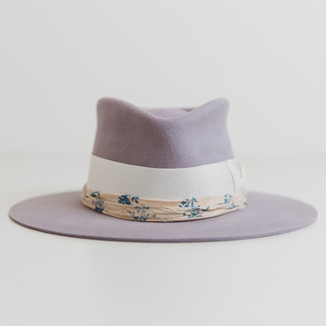 Front view of The Wisteria lilac felt hat by PHYLLi Designs with ivory grosgrain band and sari silk trim.