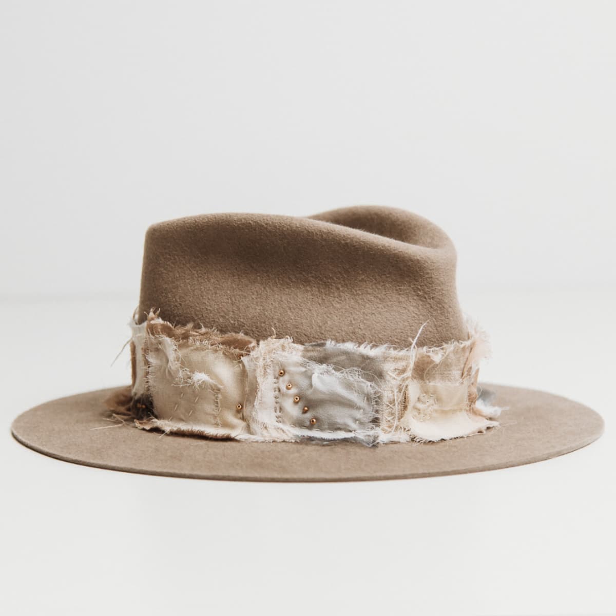 Front right angle of the Wabi Limited Edition Sahara felt hat by PHYLLi Designs with Wabi Sabi patch band in linen, cotton, organza and georgette silk.