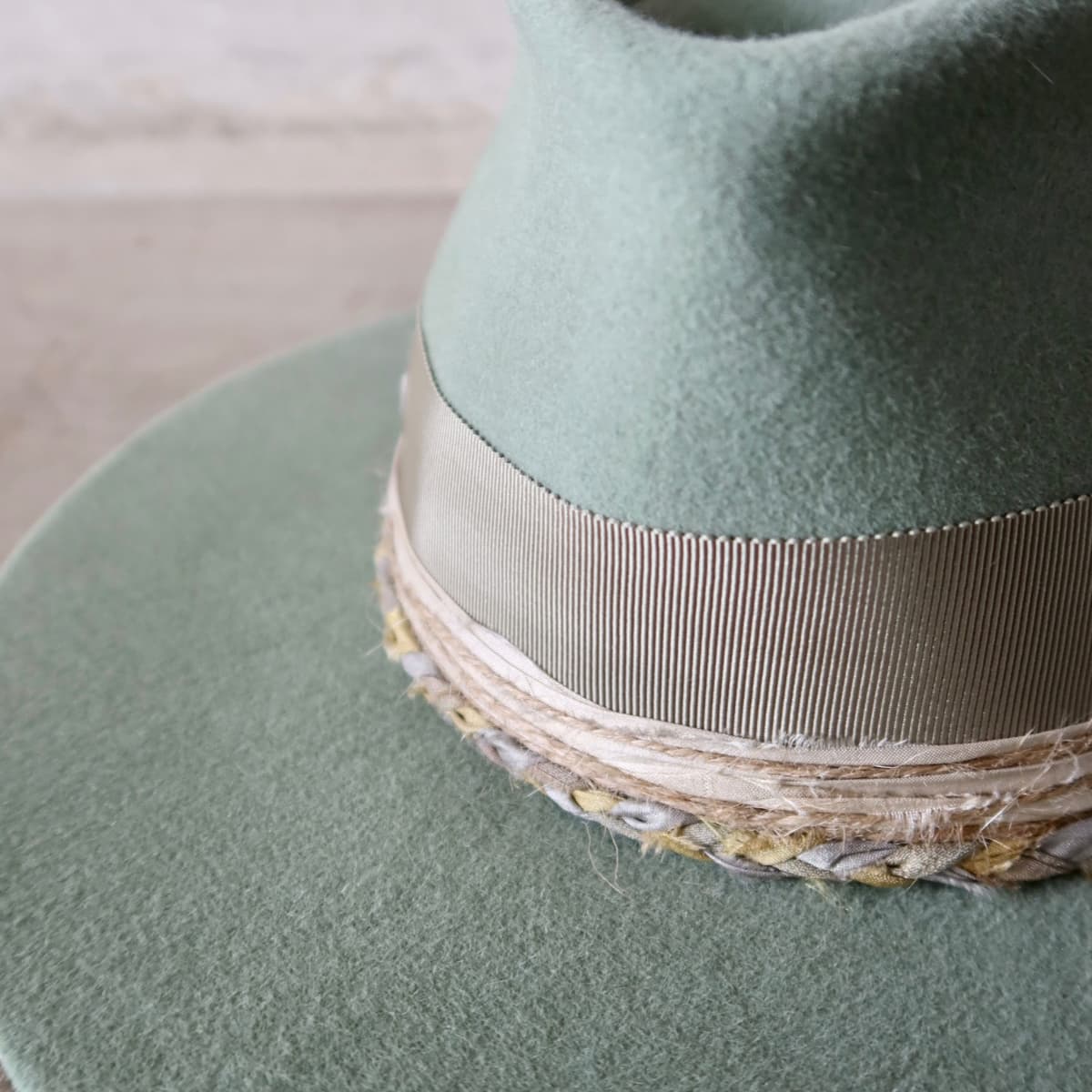 Close up detail of the Wheatley Limited Edition felt hat showing distressed sari silk trimming in tie dye sand and sky blue.