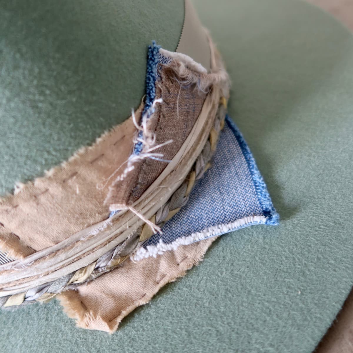 Close up detail of the Wheatley Limited Edition felt hat showing wabi sabi linen and denim patches.