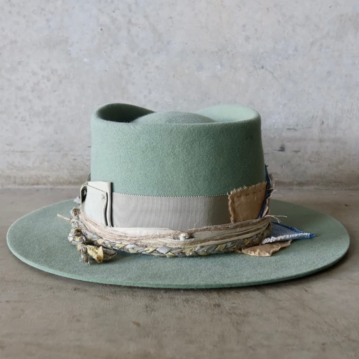 Back view of the Eucalyptus felt hat Wheatley Limited Edition by PHYLLi Designs featuring Japanese grosgrain bow band and layered sari silk and twine trims.