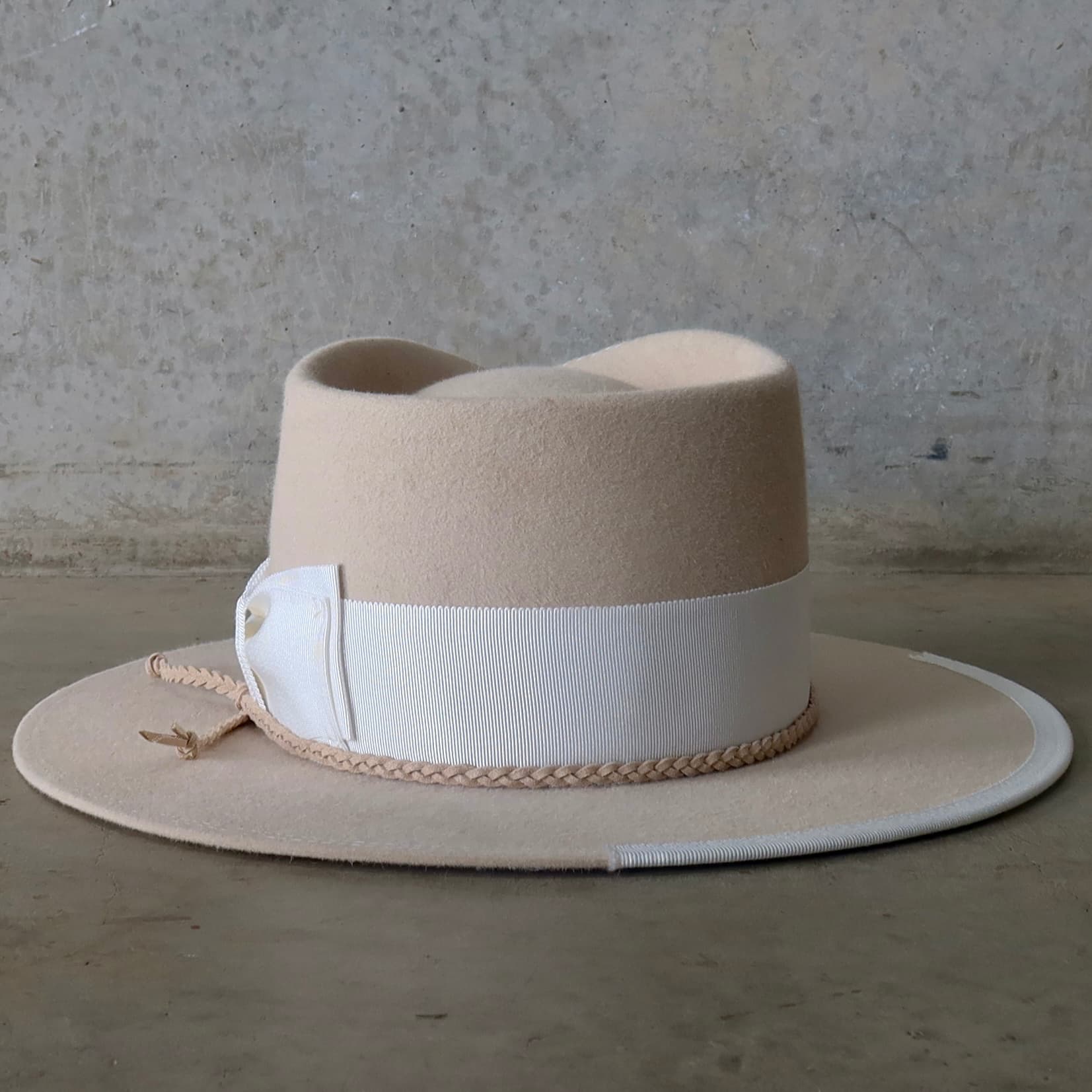 Back view of the beige felt hat Yolande by PHYLLi Designs featuring nude plaited suede string trim.