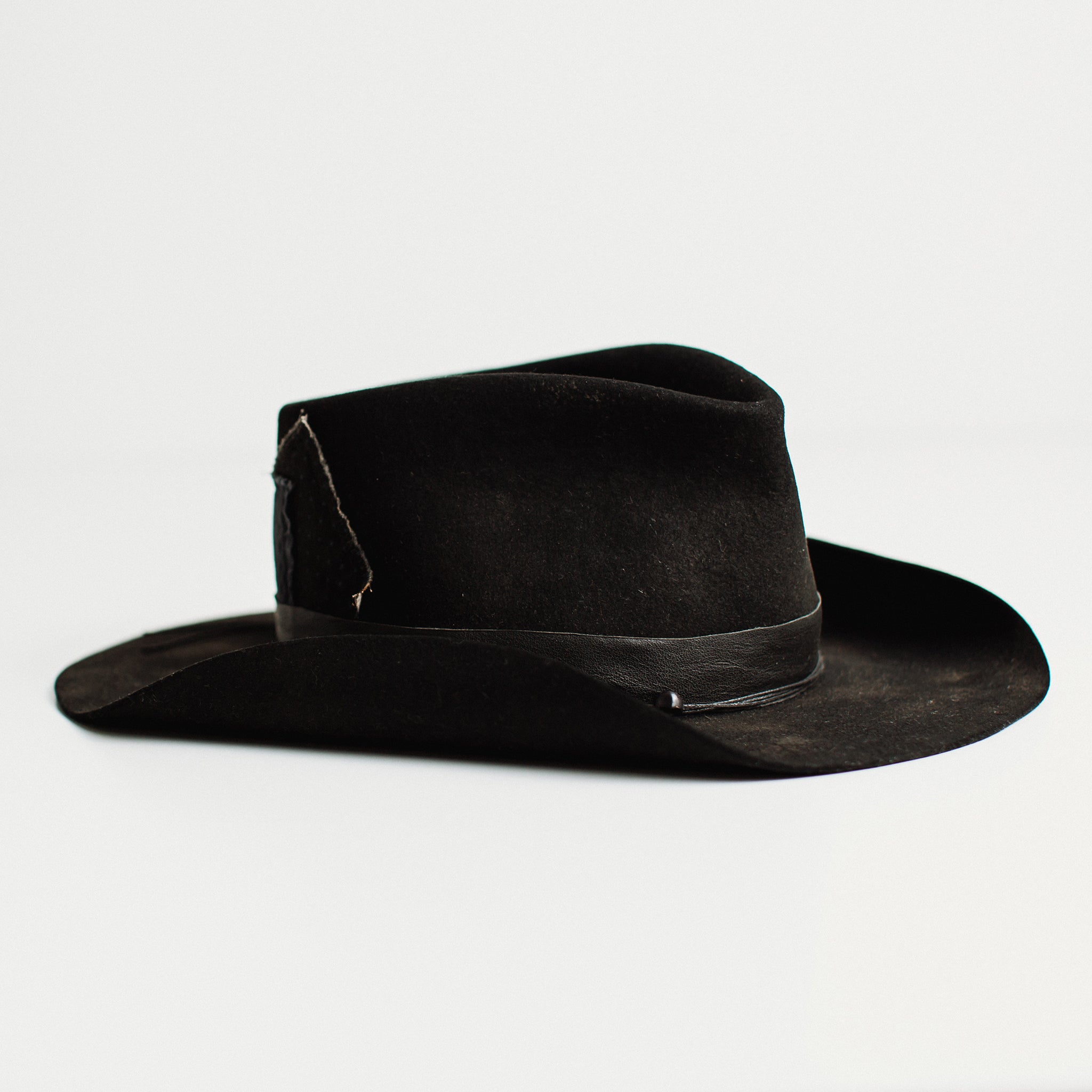 Right angle – The Urban Cowboy by PHYLLi, handcrafted Black felt hat with suede string, Japanese patches, and skull beading.