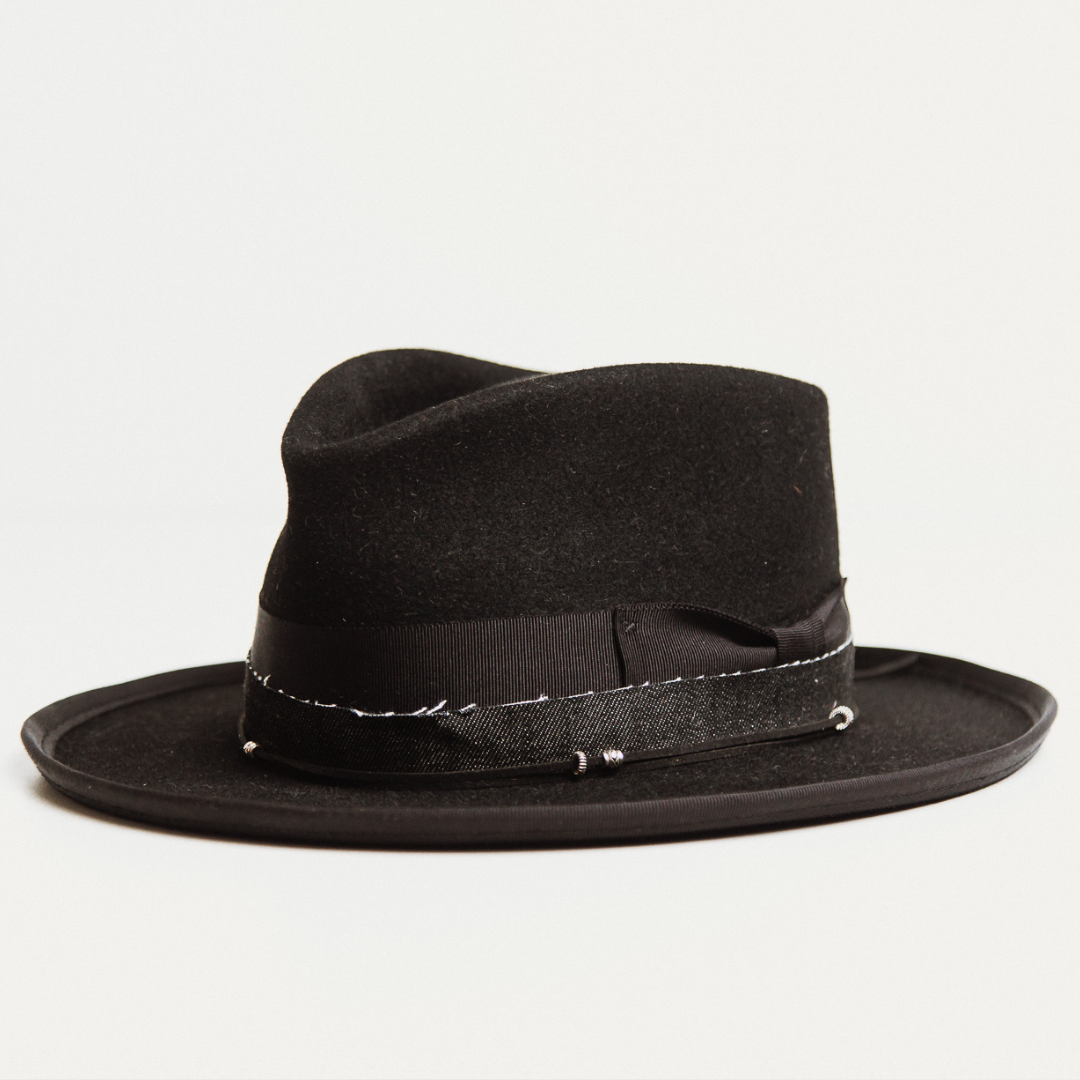 Left angle - The Rocker by PHYLLi, a Black felt hat with Black grosgrain bow, brim trim, suede string and silver hardware.