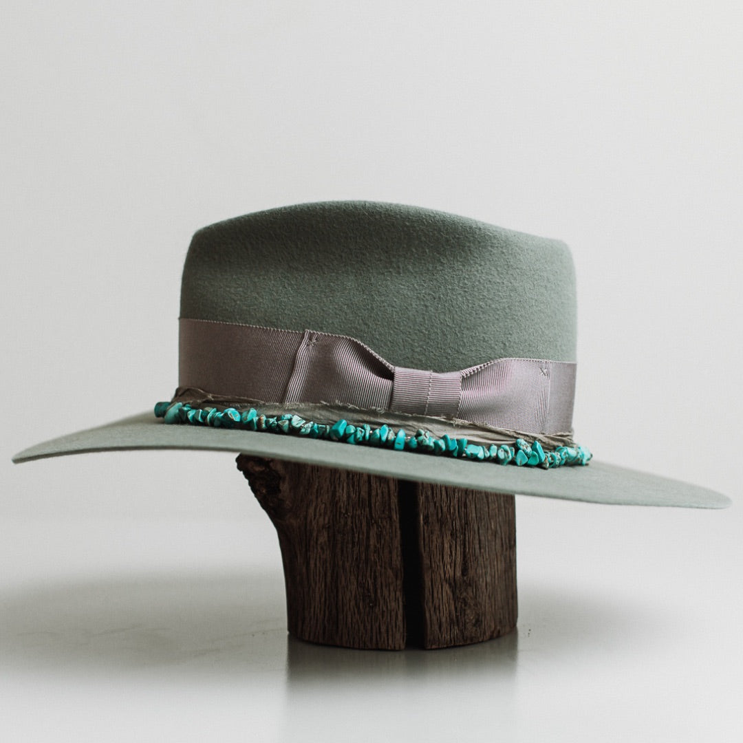 Left side view of the Aurora sage felt hat by PHYLLi Designs with dove grosgrain ribbon band and sari silk trimming in steel grey.