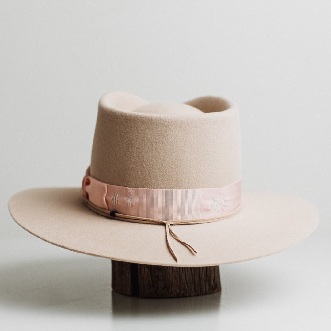 Back view of the Curlewis beige felt hat by PHYLLi Designs featuring distressed sherbet pink grosgrain bow band.