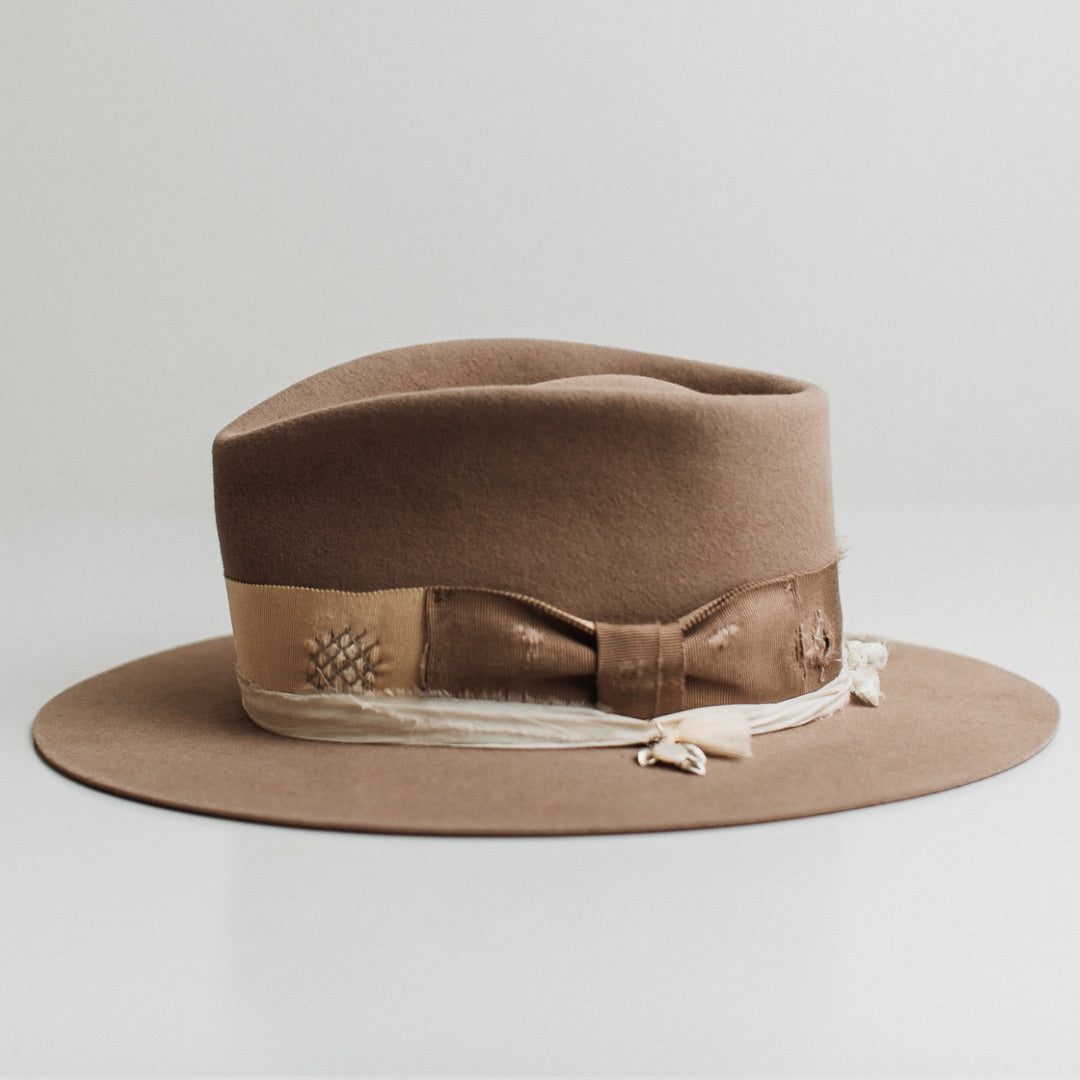 Left side view of the Enso sahara felt hat by PHYLLi Designs with ivory sari silk trimming and distressed patchwork.