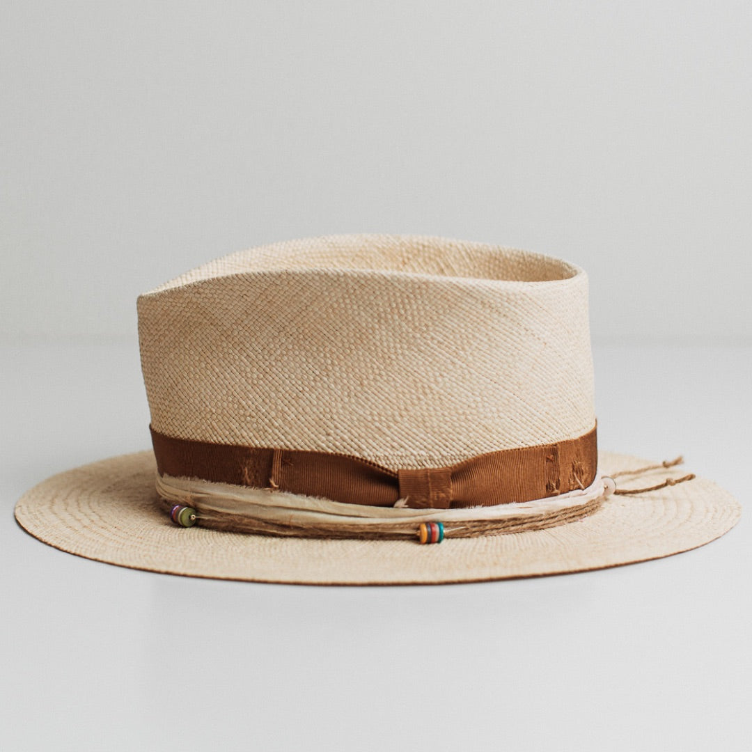 Left side view of the Mango natural Panama hat by PHYLLi Designs with twine wrap and rainbow disc bead clusters.