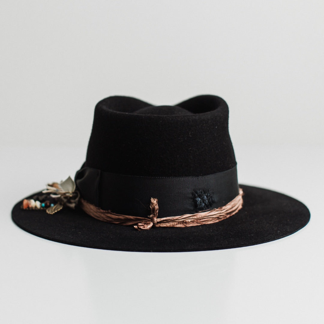 Back view of the Newmarket dark navy felt hat by PHYLLi Designs featuring distressed dark navy grosgrain band with darned patch stitching.