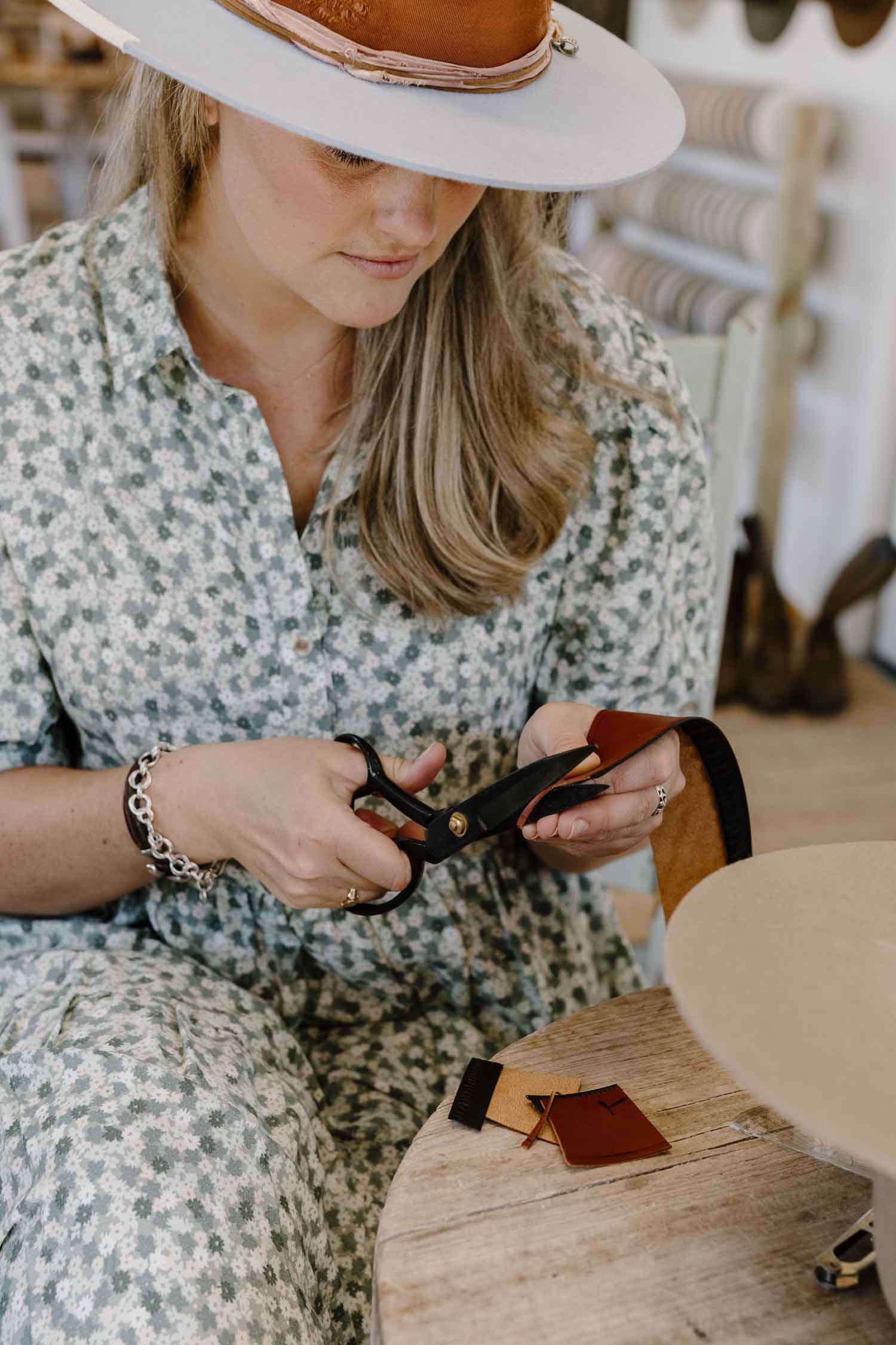 Laura Hall hand-cutting a leather sweatband to size for a custom felt hat.