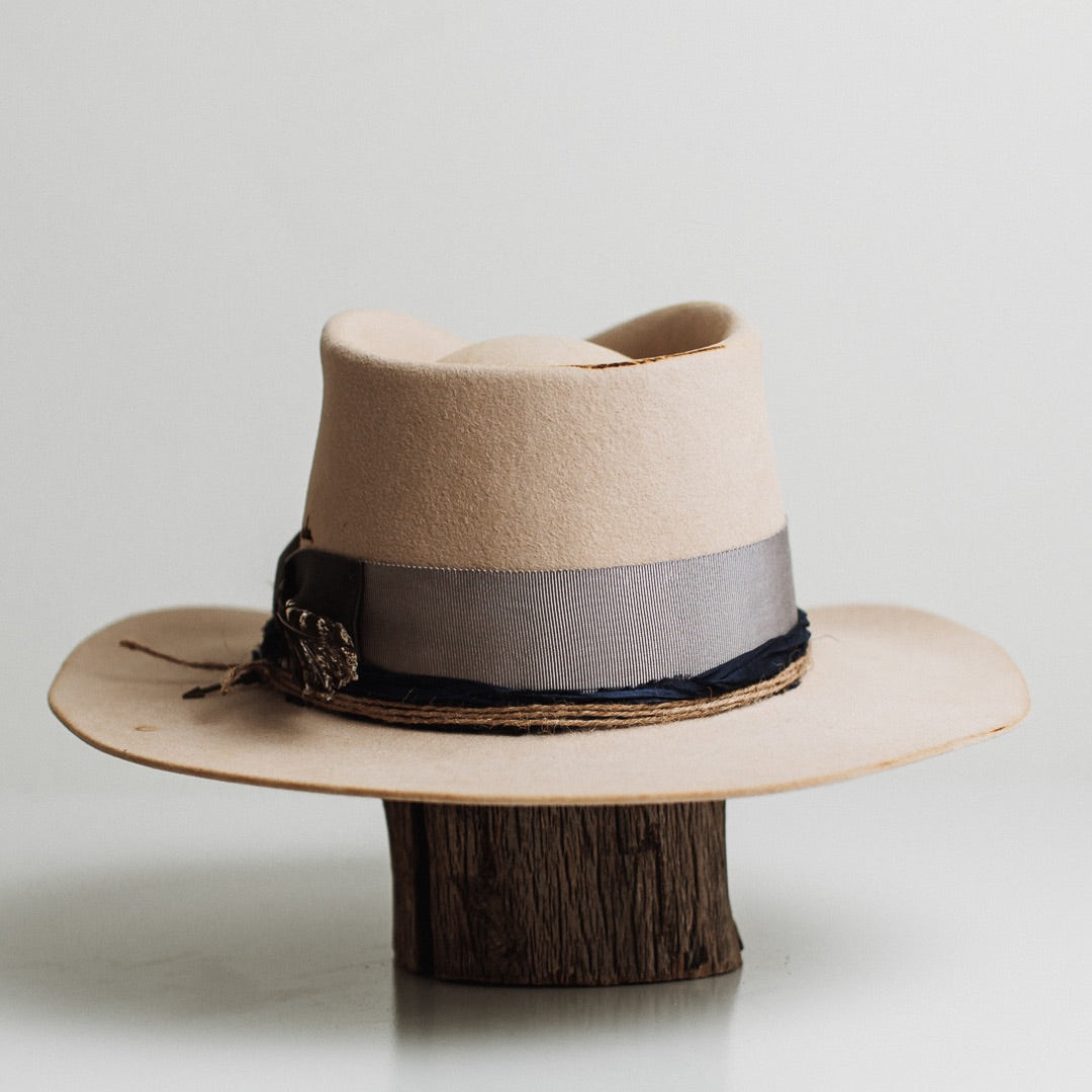 Back view of the Wrangler beige distressed felt hat by PHYLLi Designs featuring burnt branded yeeha text on the crown.
