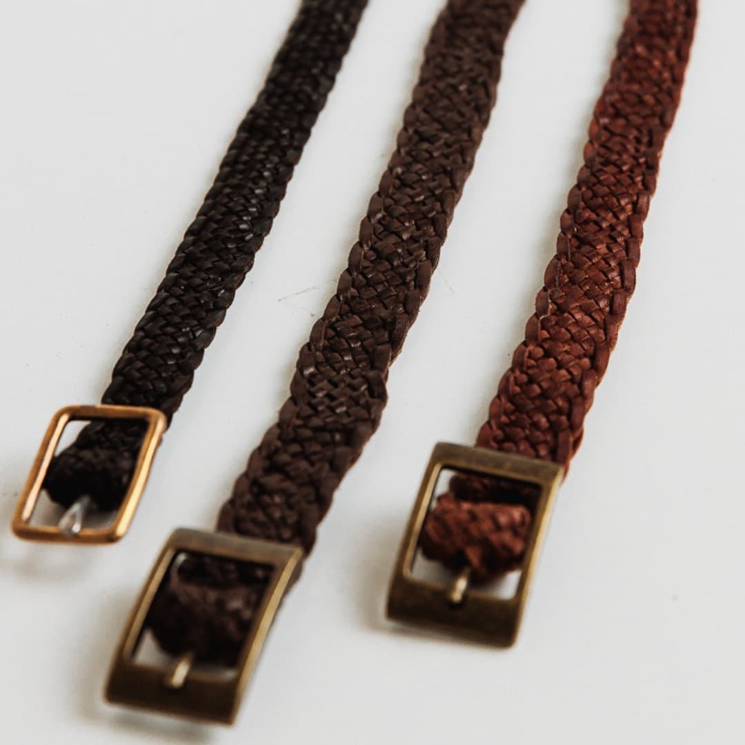 12 strand plaited leather hat bands in Chocolate with bronze buckles by PHYLLi Designs on a white background. 
