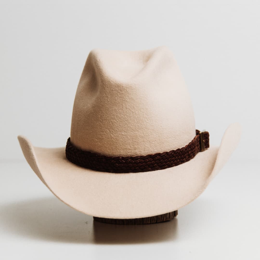 12 Strand Plaited Hat Band featuring chestnut plaited kangaroo hide with antique bronze buckle on a beige felt cowboy hat by PHYLLi Designs.