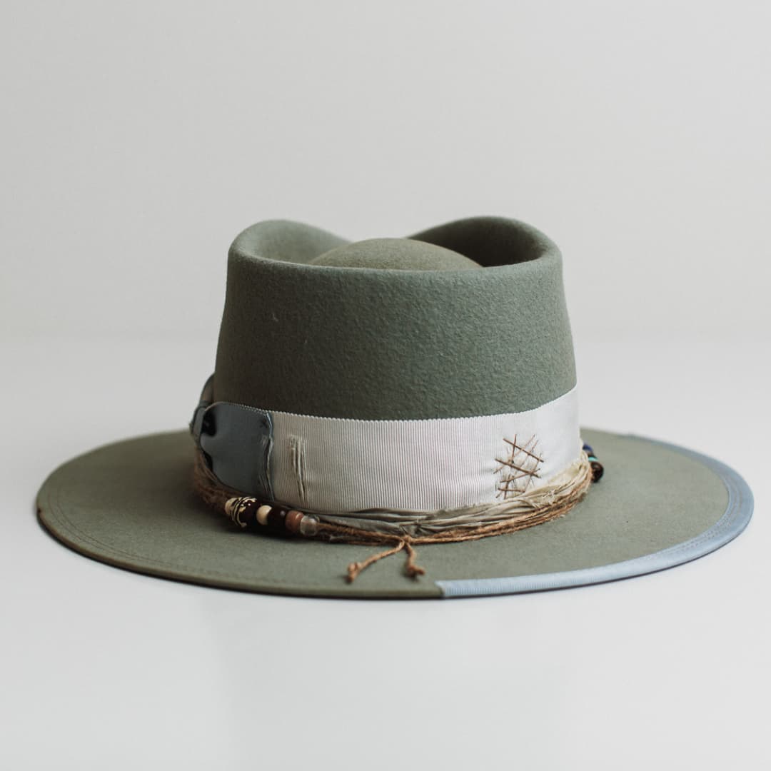 Back view of the Accra sage felt hat by PHYLLi Designs featuring distressed darned patches in taupe.