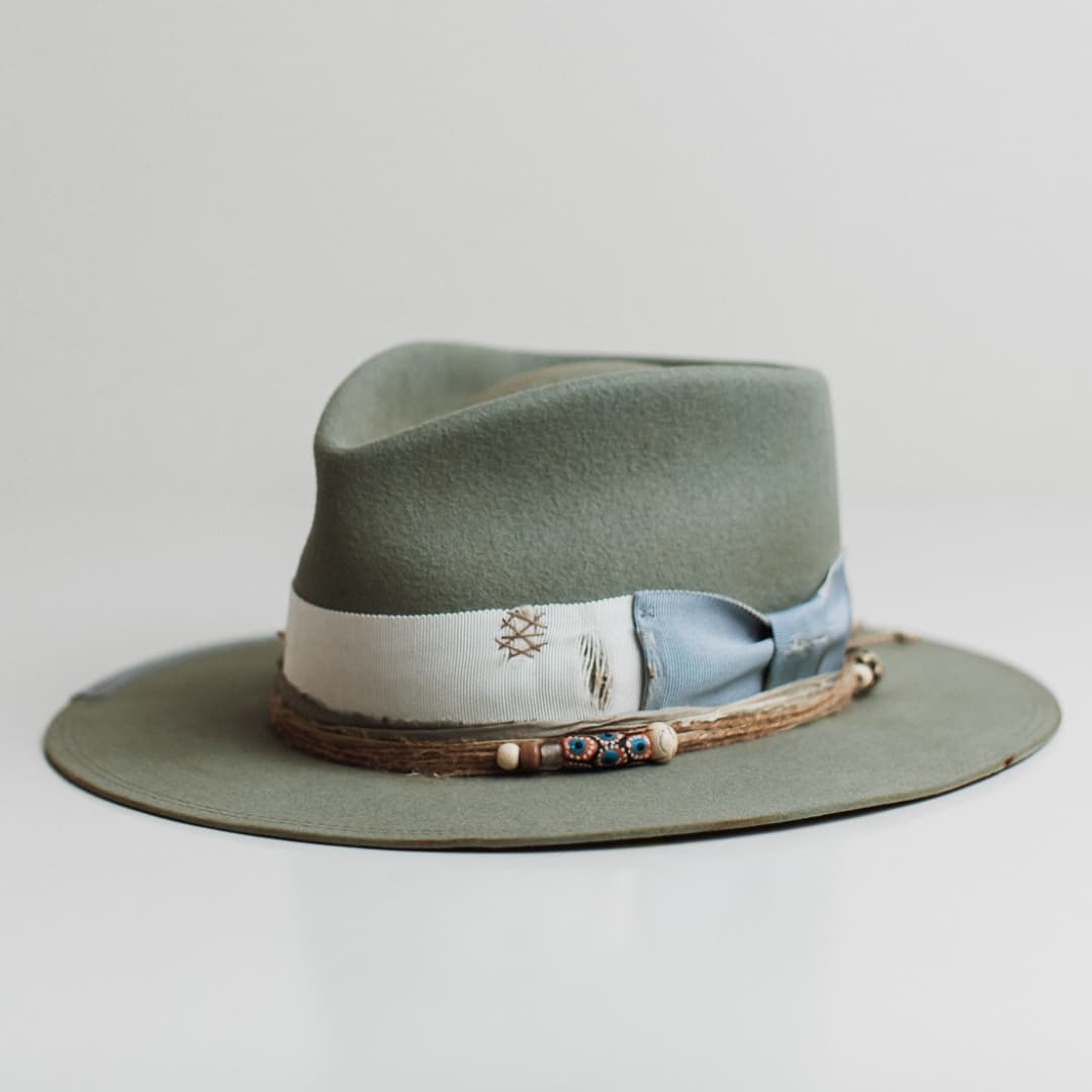 Front left angle of the Accra sage felt hat by PHYLLi Designs with ivory grosgrain band and cornflower bow.