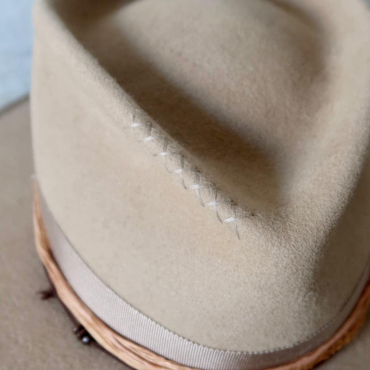 Close up detail of the Alexander felt hat showing hand stitched crosses in Taupe on the crown.
