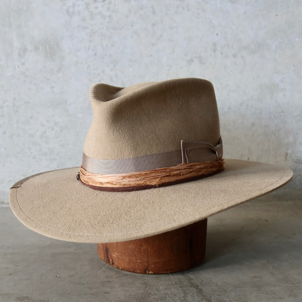 Front left angle of the Alexander Camel felt hat by PHYLLi Designs with taupe grosgrain band and copper sari silk trimming.