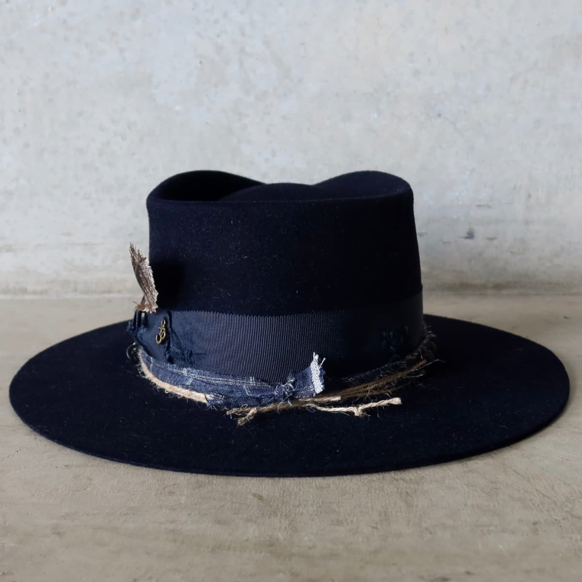 Back view of the Dark Navy felt hat Armadale by PHYLLi Designs featuring distressed darned patches and grosgrain bow band.