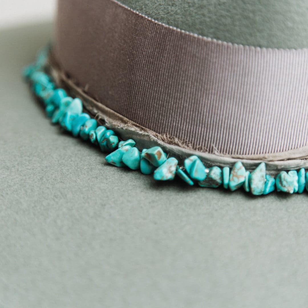 Close up detail of the Aurora felt hat showing dove Japanese grosgrain bow band and turquoise stone hat necklace.