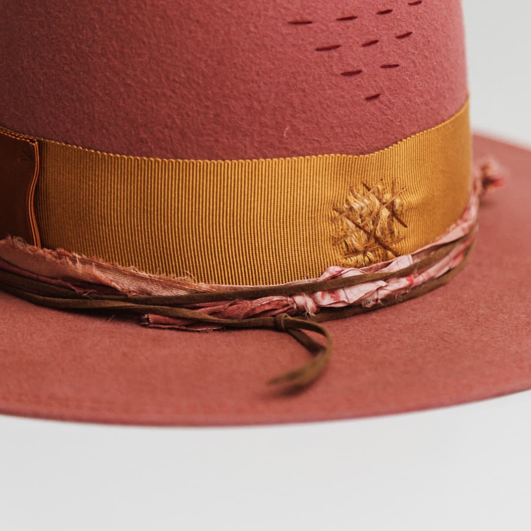 Close up detail of the Barbados Rose felt hat showing watermelon double brim stitch and candy and rose sari silk trimming.
