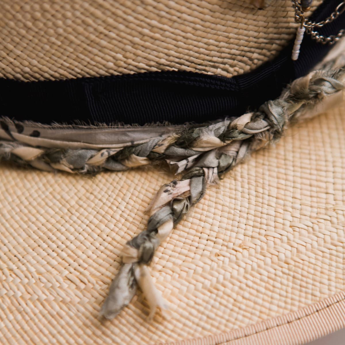Close up detail of the Blue Jean Panama hat showing plaited sari silk trim in ivory, olive and teal.
