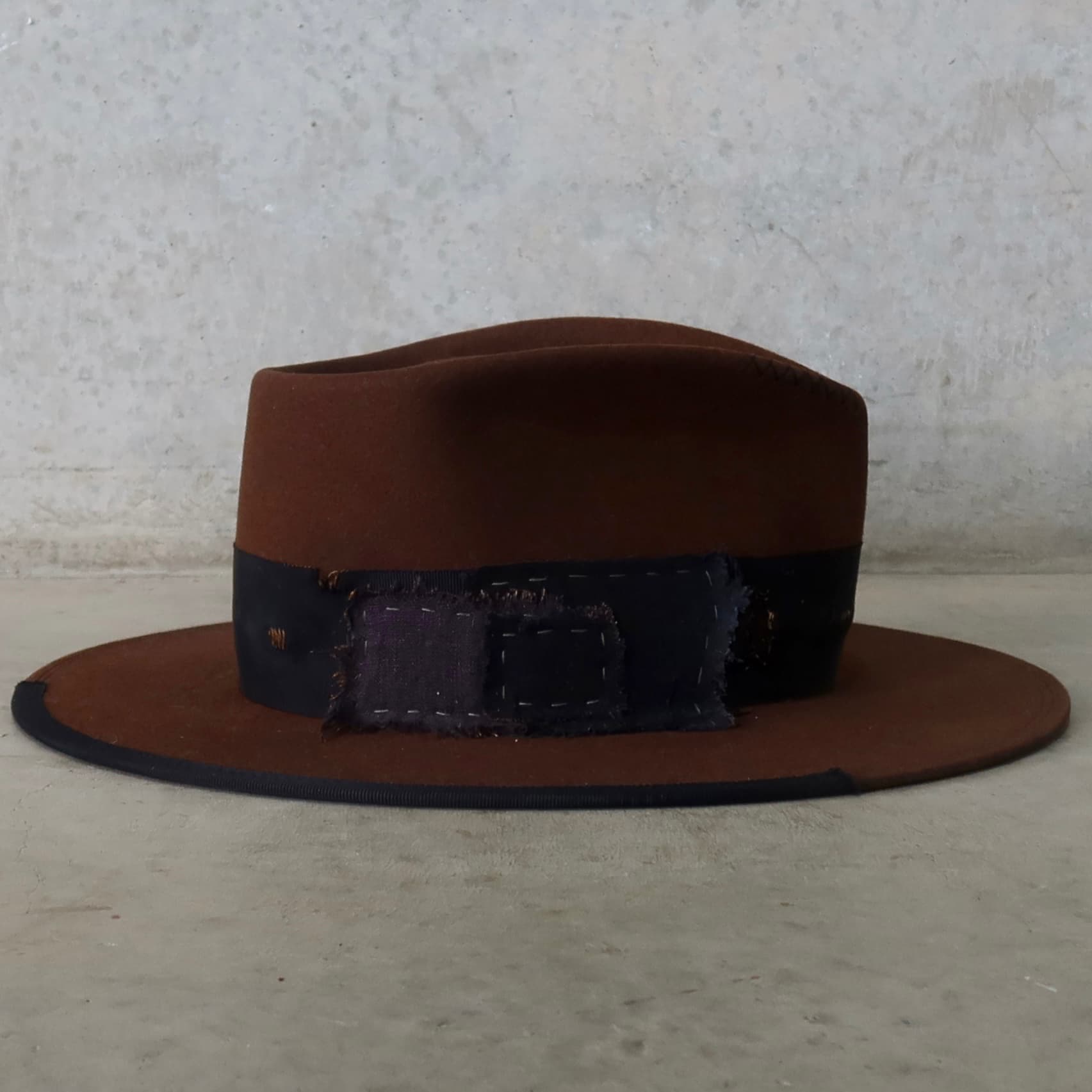 Right side view of the chocolate felt hat Brenner Limited Edition by PHYLLi Designs showcasing distressed denim and linen patch details.