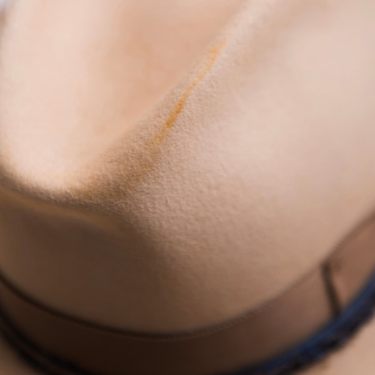 Close up detail of the Buckler felt hat showing distressed felt texture and natural wear markings.