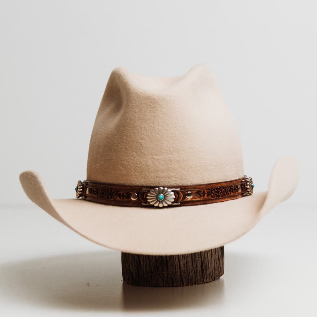 Phylli x Buffalo Girl Rugged Desert Hat Band Western Floral with antique brown hand tooled leather hat band featuring three Western Floral turquoise conchos on a beige felt cowboy hat by PHYLLi Designs.