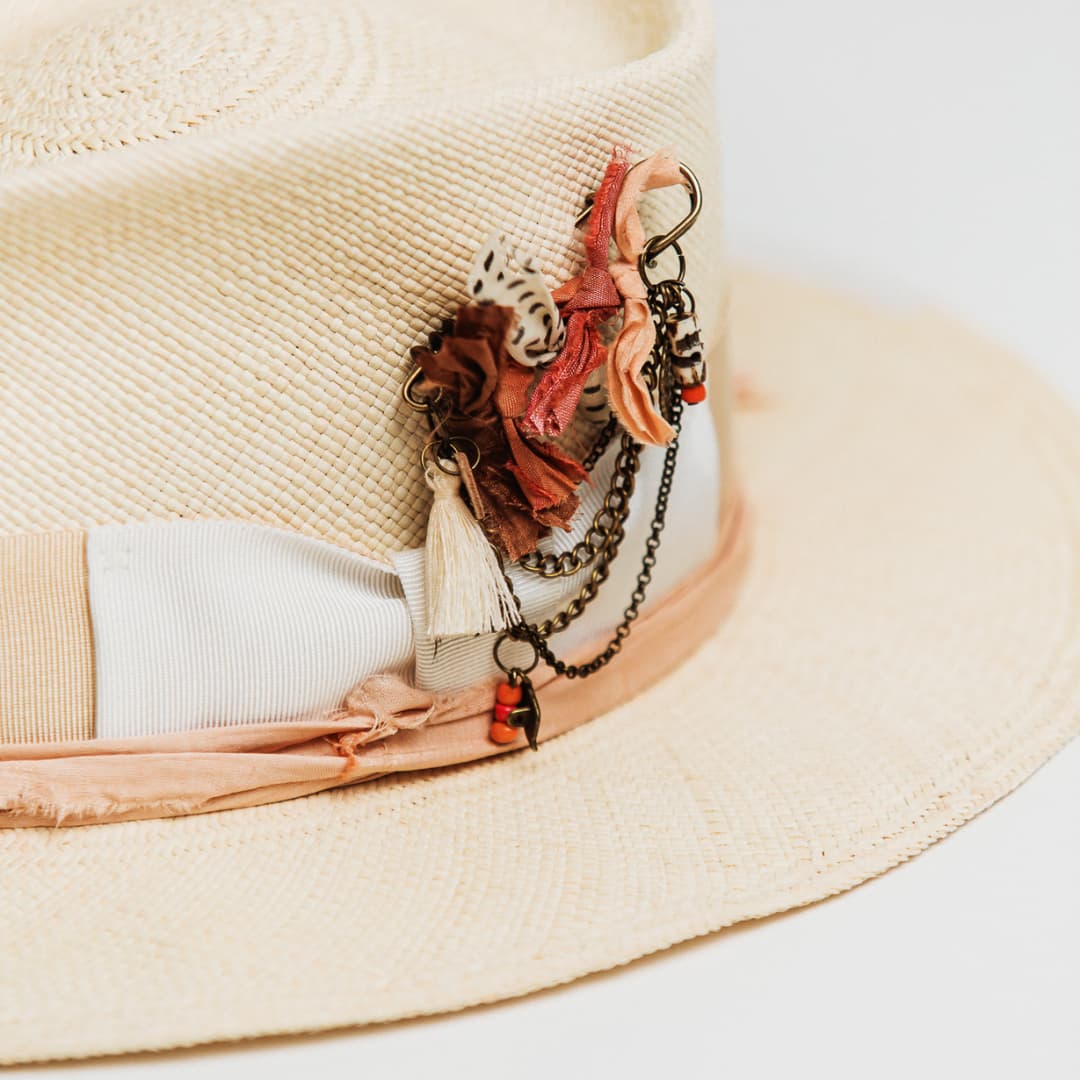 Close up of bronze chunky hat pin on Calipso Panama hat with Ivory tassel and charms.