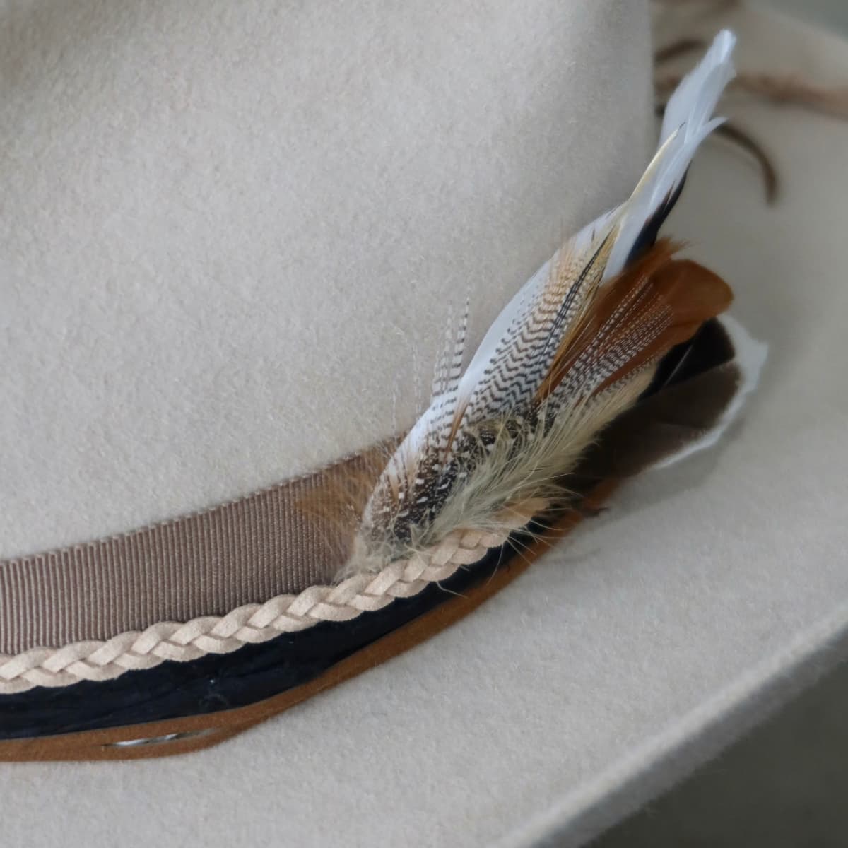 Close up detail of the Casey Beige cowboy hat showing fallen feather bunch layered into the trim.
